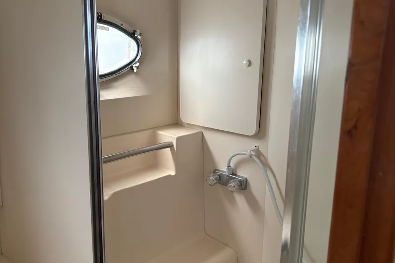 Slide: The Image of Bathroom interior of a 1999 Silverton 392 yacht with porthole and shower fixtures. - 16
