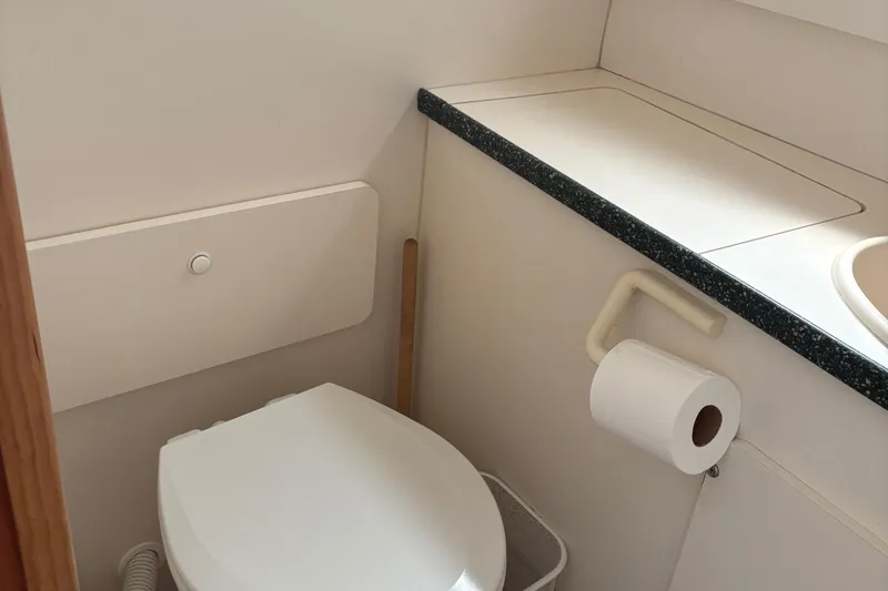 Slide: The Image of Bathroom interior of a 1999 Silverton 392 yacht, featuring a toilet and countertop. - 18
