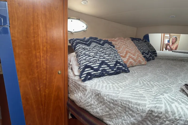 Slide: The Image of Cozy cabin interior of 1999 Silverton 392 yacht with patterned pillows and wooden door. - 22