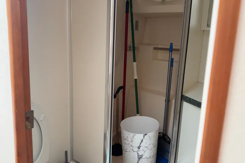Slide: The Image of 1999 Silverton 392 boat interior with cleaning supplies and a toilet. - 23