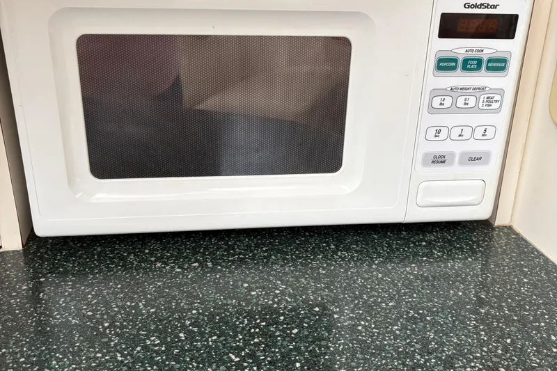 Slide: The Image of White microwave on a speckled countertop with control panel and digital display. - 29