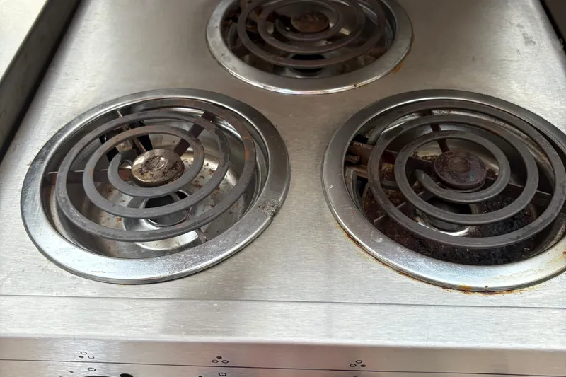 Slide: The Image of Electric stove burners on a Silverton 392, 1999 model, with visible wear and rust. - 31