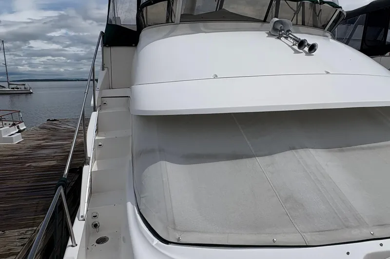 Slide: The Image of 1999 Silverton 392 yacht docked by the water on a cloudy day. - 40