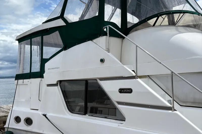 Slide: The Image of 1999 Silverton 392 yacht with green canopy docked by the water. - 41