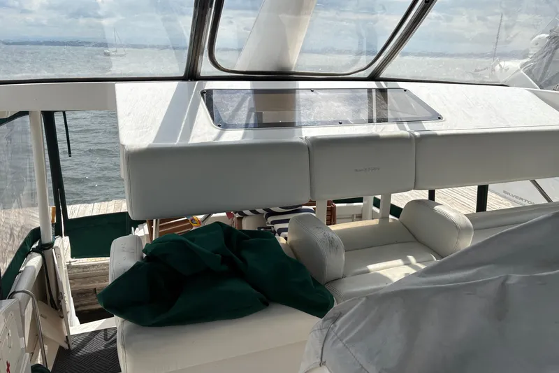 Slide: The Image of 1999 Silverton 392 yacht interior with white seating and ocean view. - 6