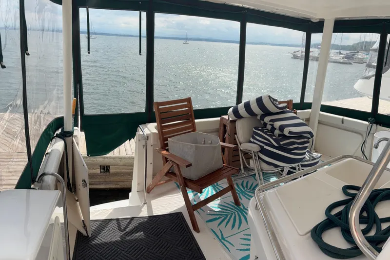 Slide: The Image of 1999 Silverton 392 boat interior with chairs, cushions, and scenic water view. - 9