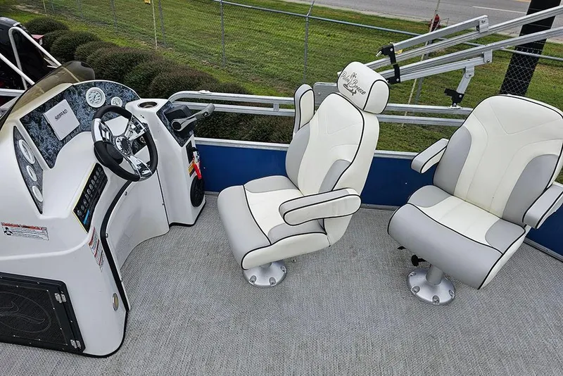Slide: The Image of 2019 Lexington 321 boat interior with steering console and two white captain chairs. - 10