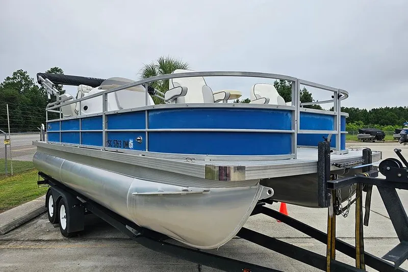 Slide: The Image of 2019 Lexington 321 pontoon boat on trailer, blue and silver design. - 5