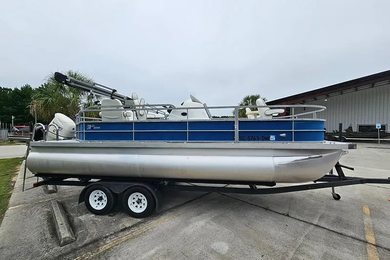 Slide: The Image of 2019 Lexington 321 pontoon boat on trailer, parked outdoors. - 6