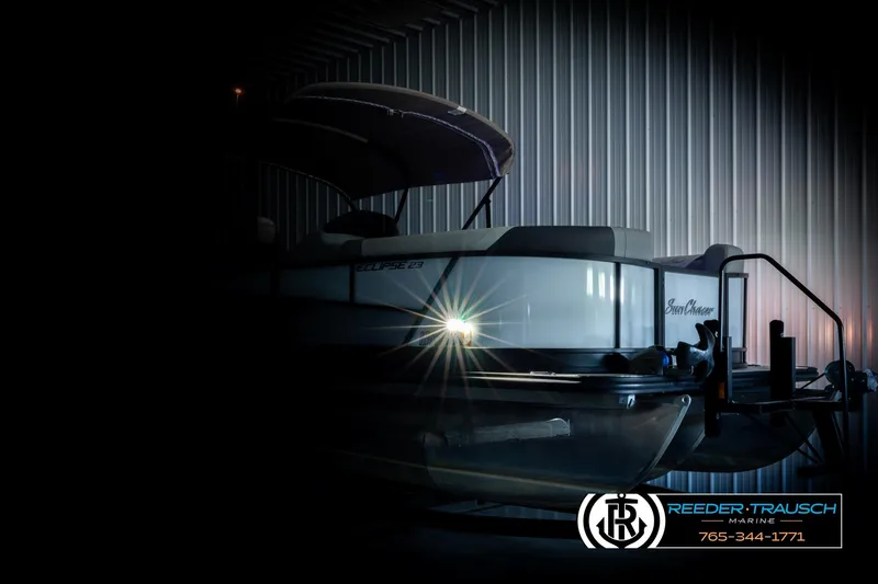 Slide: The Image of 2023 SunChaser 23 Eclipse SSB pontoon boat in dimly lit storage facility. - 5