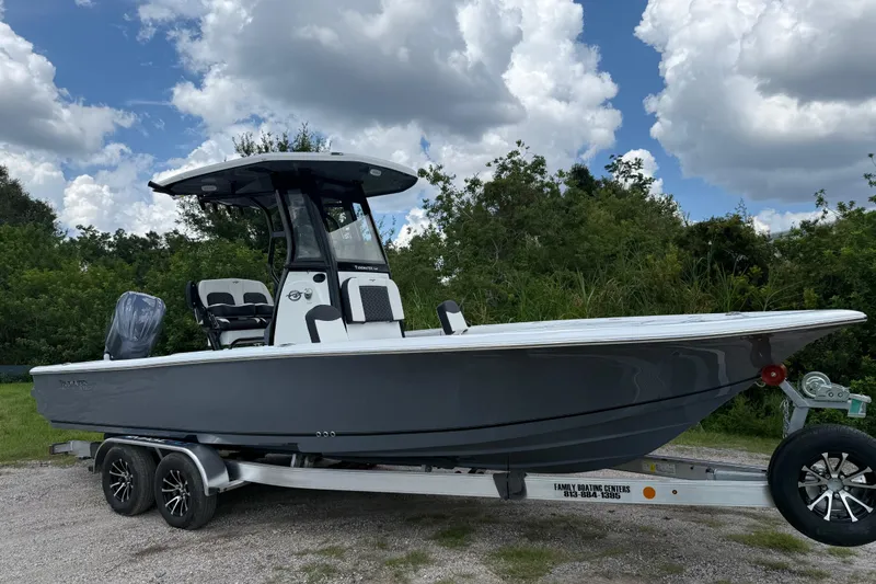 The Image of 2026 Tidewater 2500 Carolina Bay boat on trailer, parked outdoors under cloudy sky. - 1