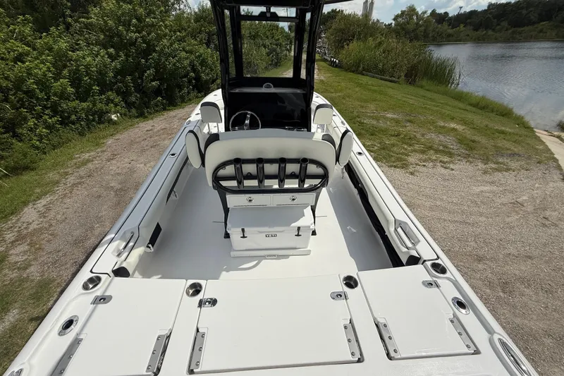 Slide: The Image of 2026 Tidewater 2500 Carolina Bay boat interior, featuring spacious seating and storage, near a serene lake. - 14