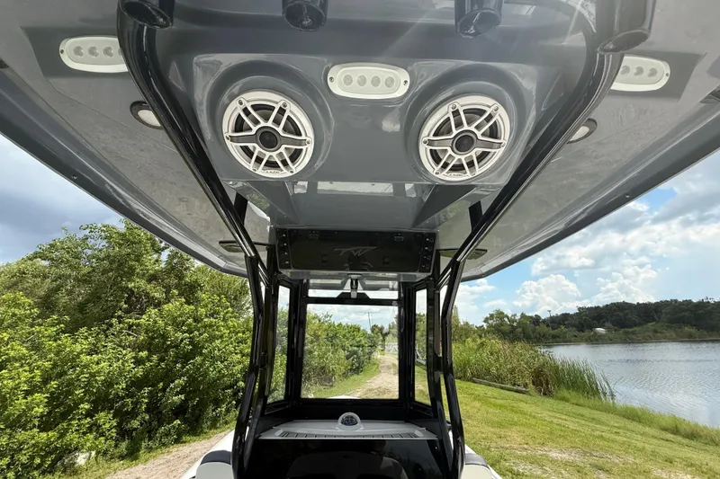 Slide: The Image of 2026 Tidewater 2500 Carolina Bay boat with speakers and canopy, near a scenic waterway. - 18