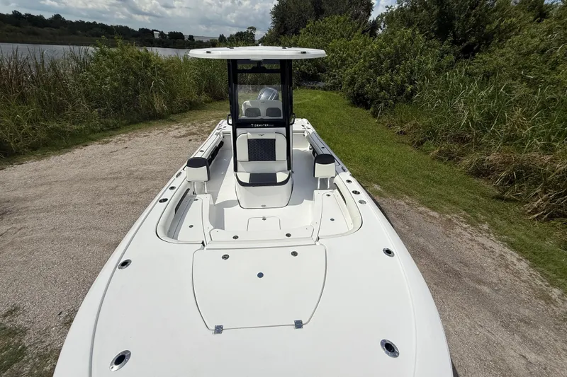 Slide: The Image of 2026 Tidewater 2500 Carolina Bay boat on a grassy shore, showcasing sleek design and spacious deck. - 22