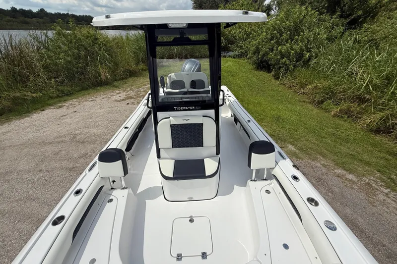 Slide: The Image of 2026 Tidewater 2500 Carolina Bay boat, sleek design, parked near lush greenery. - 23