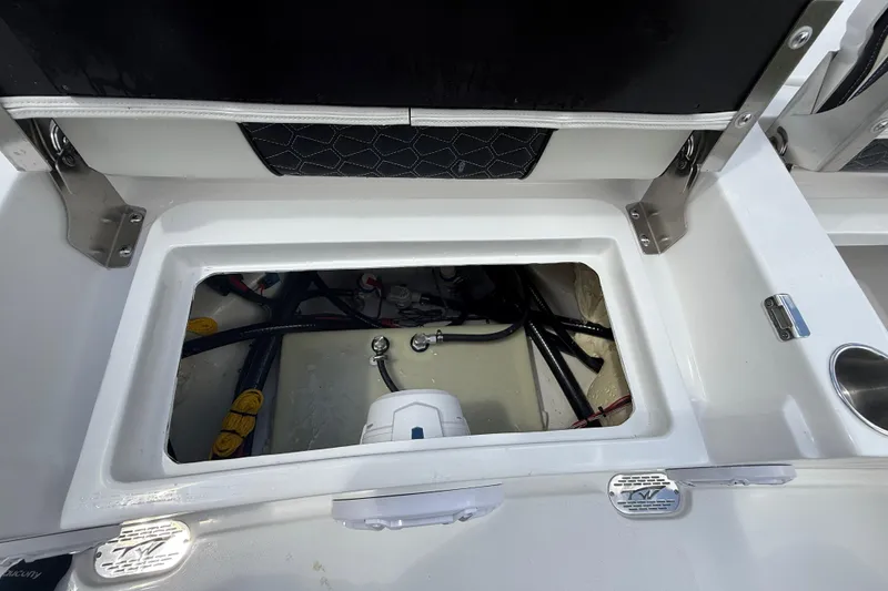 Slide: The Image of 2026 Tidewater 2500 Carolina Bay boat storage compartment with visible wiring and components. - 29