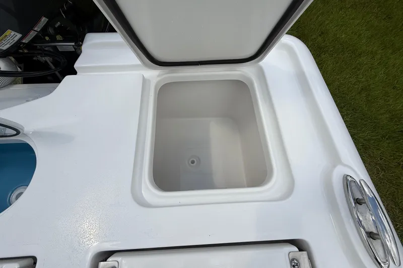 Slide: The Image of 2026 Tidewater 2500 Carolina Bay boat storage compartment, open lid, white interior. - 33