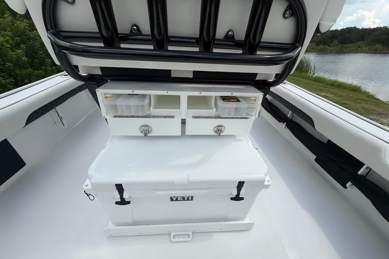 Slide: The Image of 2026 Tidewater 2500 Carolina Bay boat interior with storage compartments and Yeti cooler. - 34
