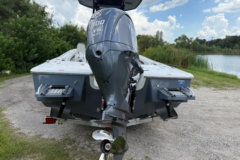 Slide: The Image of 2026 Tidewater 2500 Carolina Bay boat with powerful 300 V6 engine, parked near a scenic lake. - 4