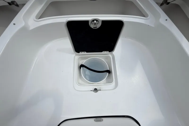 Slide: The Image of 2026 Tidewater 2500 Carolina Bay boat storage compartment with open hatch and bucket. - 40