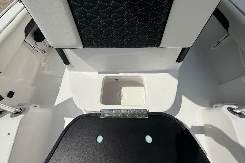 Slide: The Image of 2026 Tidewater 2500 Carolina Bay boat interior with storage compartment and cushioned seating. - 45