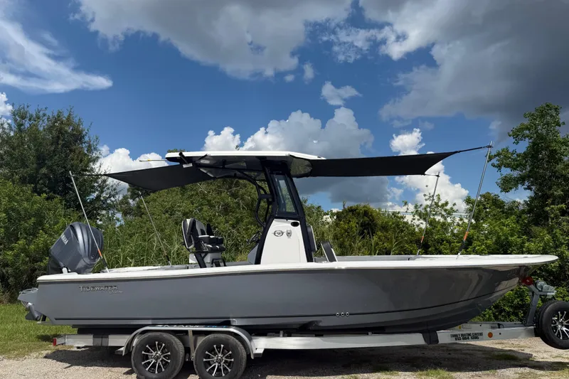 Slide: The Image of 2026 Tidewater 2500 Carolina Bay boat on trailer, under a cloudy sky. - 47