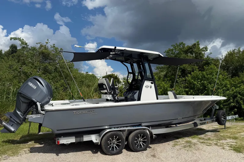 Slide: The Image of 2026 Tidewater 2500 Carolina Bay boat with Yamaha engine on trailer, under cloudy sky. - 48