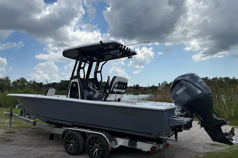Slide: The Image of 2026 Tidewater 2500 Carolina Bay boat with Yamaha engine on trailer, under cloudy sky. - 8