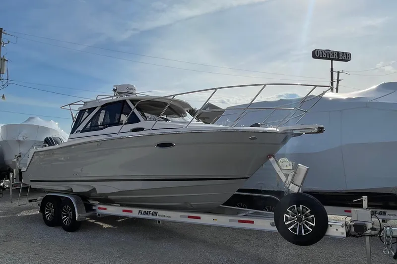 The Image of 2026 Cutwater C-248 Coupe boat on trailer, parked near an oyster bar. - 0