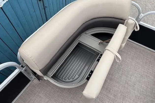 Slide: The Image of 2024 Sun Tracker Party Barge 16 DLX seating with storage compartment open. - 10