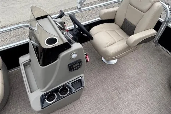 Slide: The Image of 2024 Sun Tracker Party Barge 16 DLX helm with beige captain's chair and control console. - 14