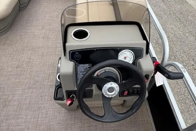 Slide: The Image of 2024 Sun Tracker Party Barge 16 DLX steering console with cup holder and gauge. - 16