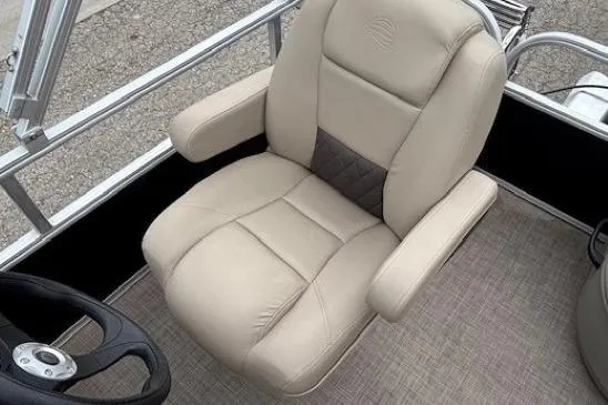 Slide: The Image of 2024 Sun Tracker Party Barge 16 DLX captain's chair, beige upholstery, steering wheel visible. - 17