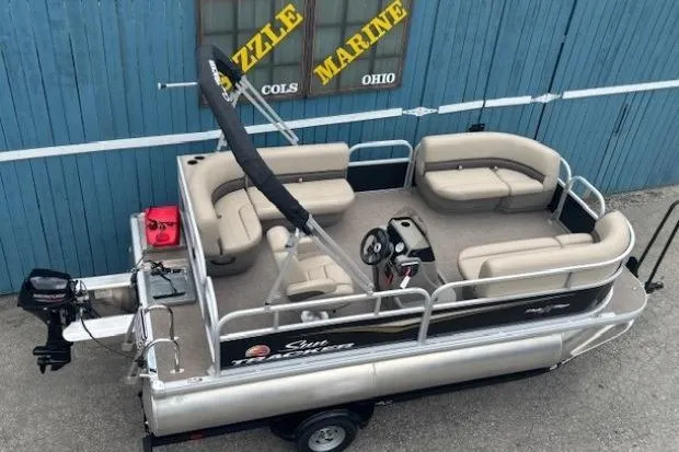 Slide: The Image of 2024 Sun Tracker Party Barge 16 DLX pontoon boat, beige seating, blue background, Sizzle Marine. - 5