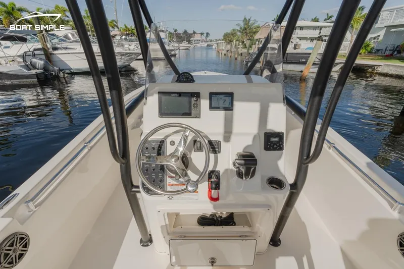 Slide: The Image of 2023 Cobia 220 Center Console boat interior with steering wheel and navigation equipment. - 5