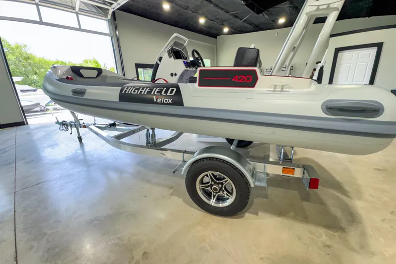 Slide: The Image of 2025 Highfield Velox 420 boat on trailer in showroom, side view. - 14
