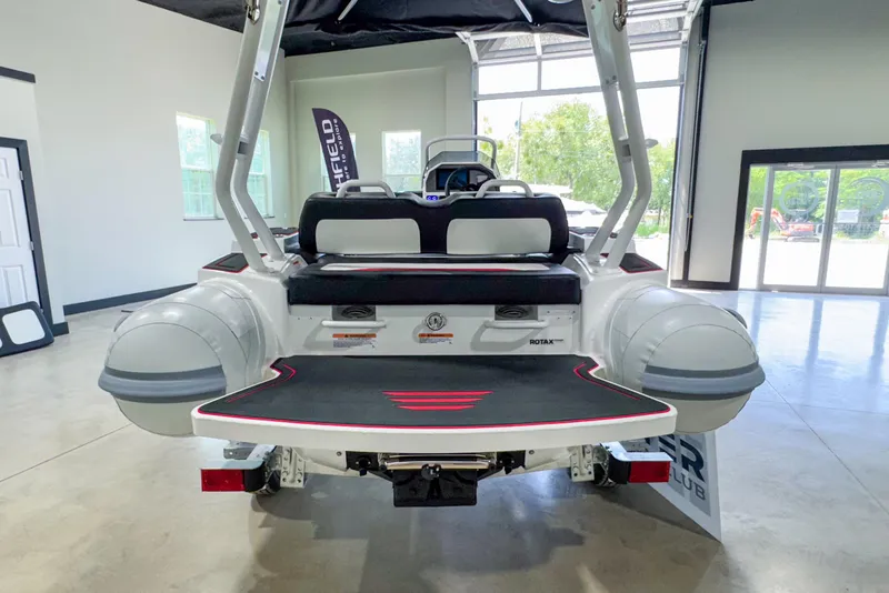 Slide: The Image of 2025 Highfield Velox 420 boat in showroom, rear view with seating and inflatable pontoons. - 18