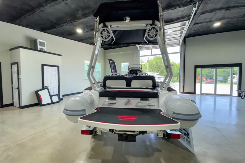 Slide: The Image of 2025 Highfield Velox 420 boat displayed indoors, showcasing rear design and seating. - 2