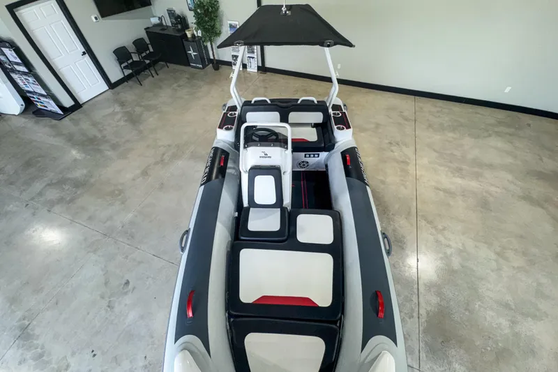 Slide: The Image of 2025 Highfield Velox 420 boat interior, showcasing seating and steering console in a showroom. - 4