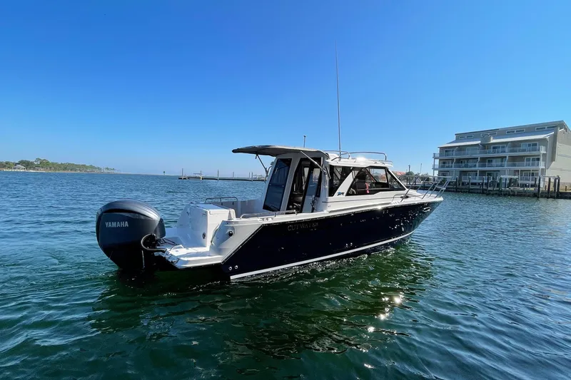 Slide: The Image of 2026 Cutwater C-248 Coupe boat on water with Yamaha engine, near modern waterfront buildings. - 2