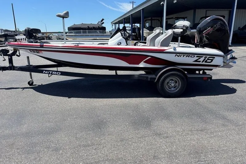 Slide: The Image of 2019 Nitro Z18 boat on trailer, white and red design, parked outdoors. - 3