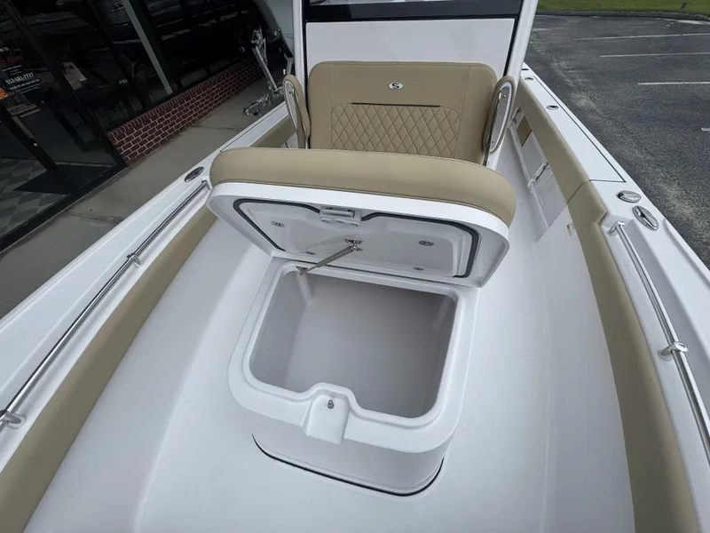 Slide: The Image of 2026 Sportsman Masters 247OE Bay Boat with open storage compartment and cushioned seating. - 24