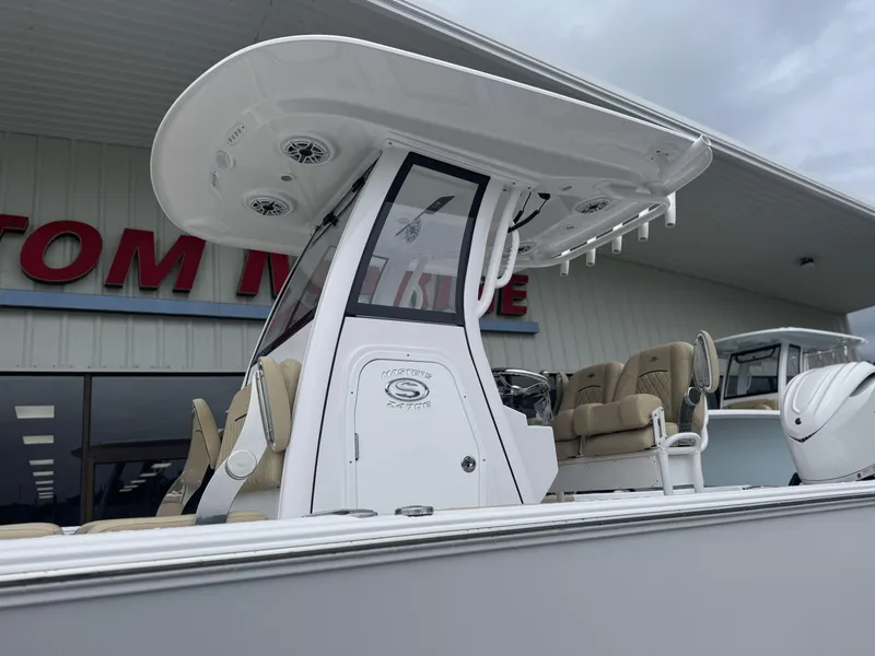 Slide: The Image of 2026 Sportsman Masters 247OE Bay Boat with T-top and seating, displayed outdoors. - 27