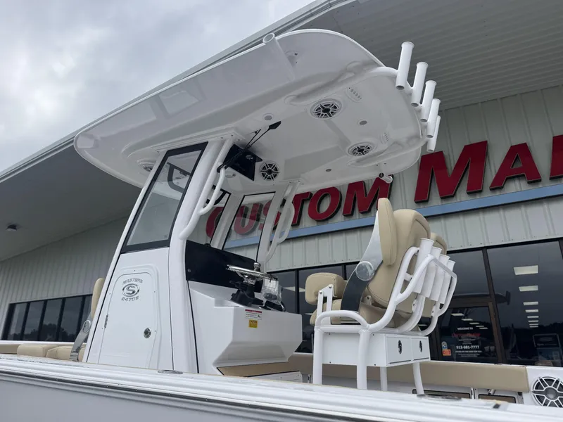 Slide: The Image of 2026 Sportsman Masters 247OE Bay Boat with T-top and seating, displayed outside showroom. - 4