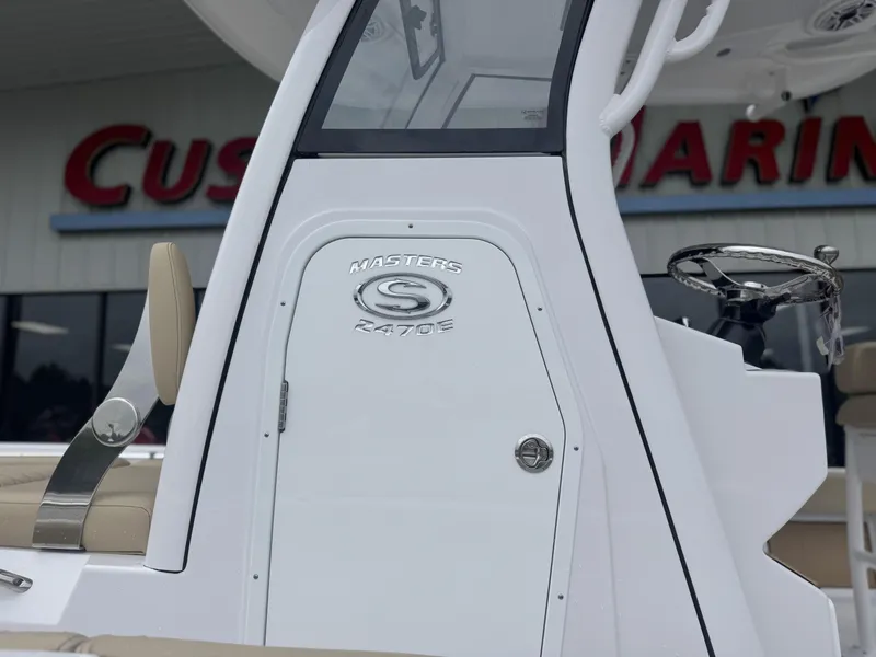 Slide: The Image of 2026 Sportsman Masters 247OE Bay Boat console with logo, displayed at a marine dealership. - 5