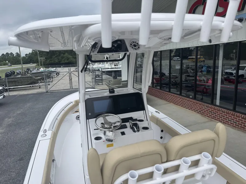 Slide: The Image of 2026 Sportsman Masters 247OE Bay Boat with modern helm and seating, parked near dealership. - 8