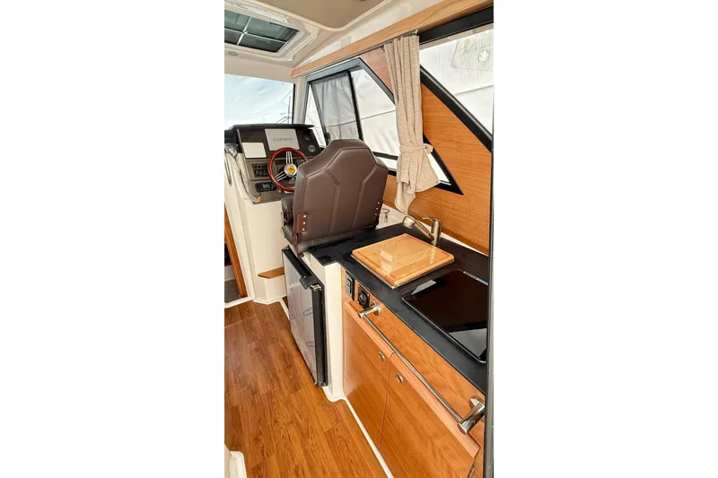 Slide: The Image of Interior of 2026 Cutwater C-248 Coupe, featuring helm, wooden cabinetry, and modern appliances. - 27
