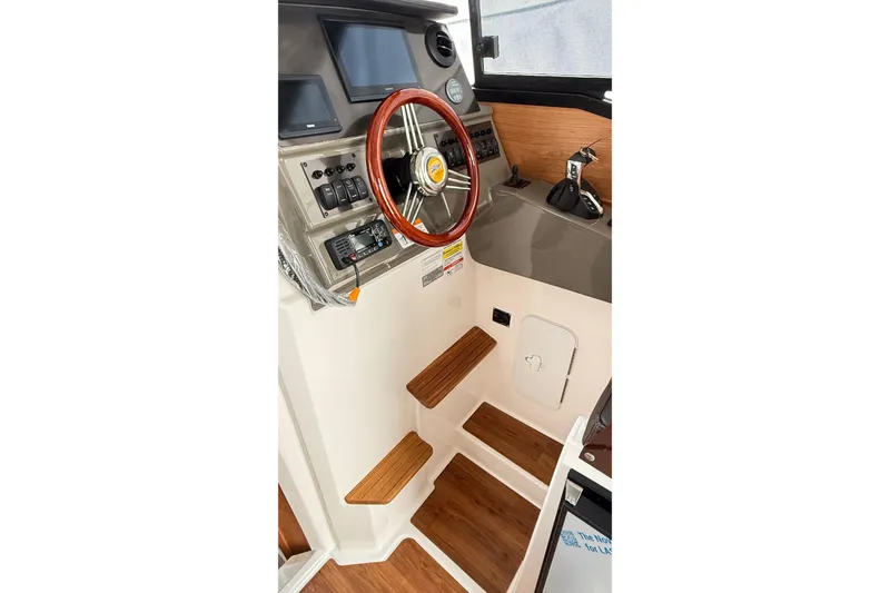 Slide: The Image of 2026 Cutwater C-248 Coupe helm with wooden steering wheel and modern controls. - 31