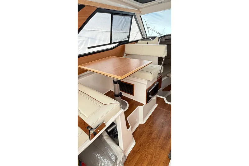 Slide: The Image of Interior of 2026 Cutwater C-248 Coupe with wooden table and cream seating. - 36