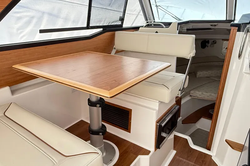 Slide: The Image of 2026 Cutwater C-248 Coupe interior with wooden table, cushioned seating, and modern design. - 37